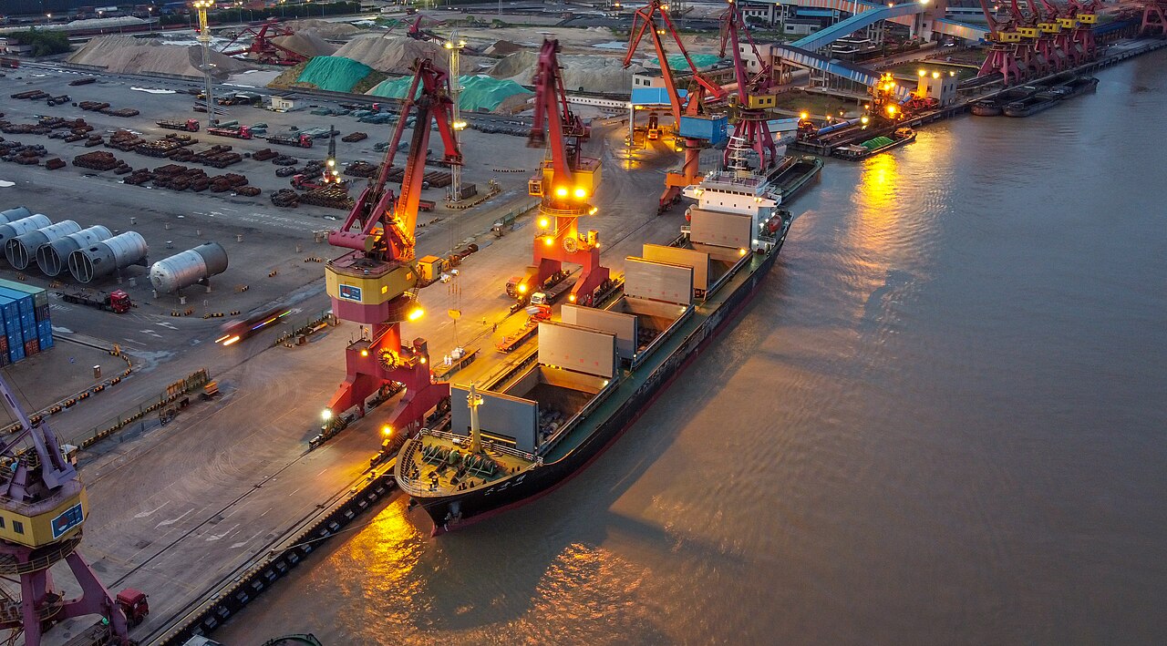 Terminal portuaria de contenedores operando al atardecer